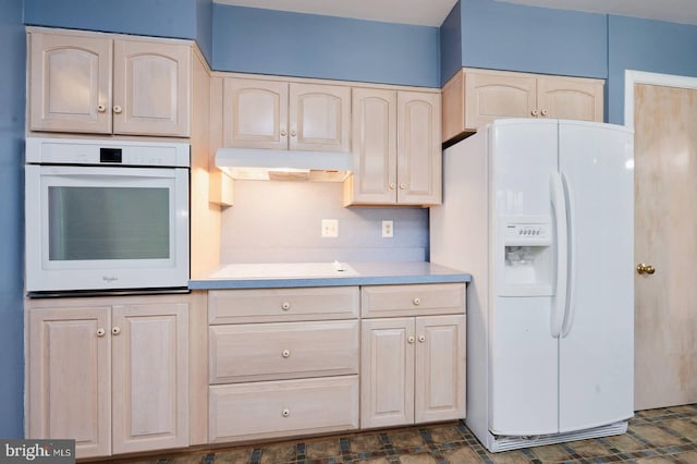 kitchen featuring white appliances, light countertops, under cabinet range hood, and light brown cabinetry