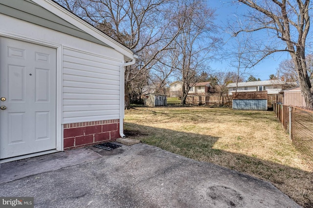 view of yard with an outbuilding, a storage unit, and fence