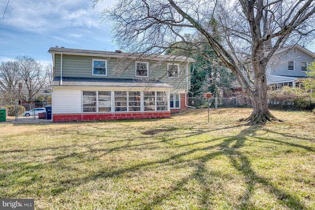 back of house with a gate, a yard, a sunroom, and fence