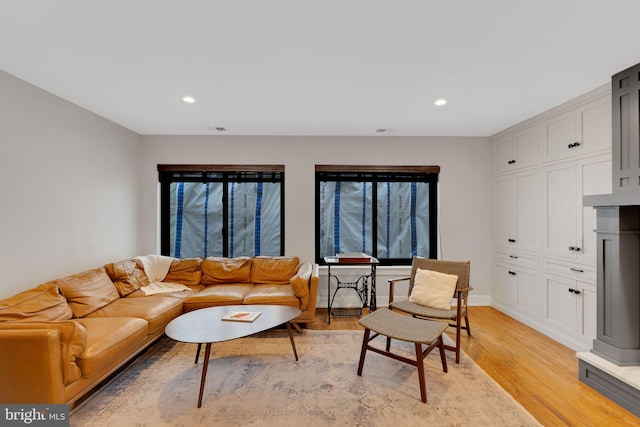 living area featuring visible vents, recessed lighting, light wood-type flooring, and baseboards