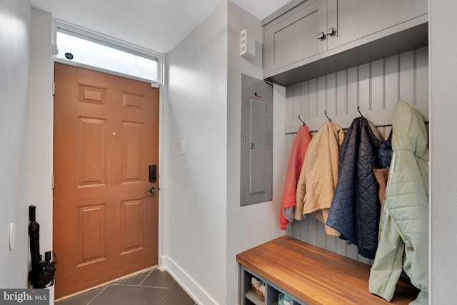 mudroom featuring dark tile patterned floors, electric panel, and baseboards