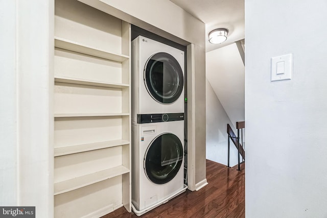 washroom featuring laundry area, stacked washer and dryer, and dark wood-type flooring