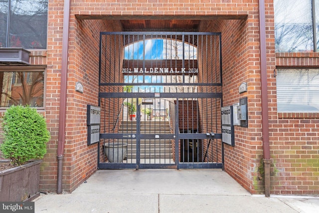 exterior space featuring brick siding and a gate