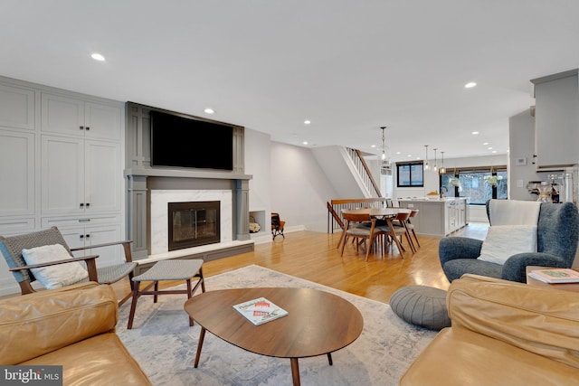 living room with recessed lighting, light wood-style flooring, and a fireplace