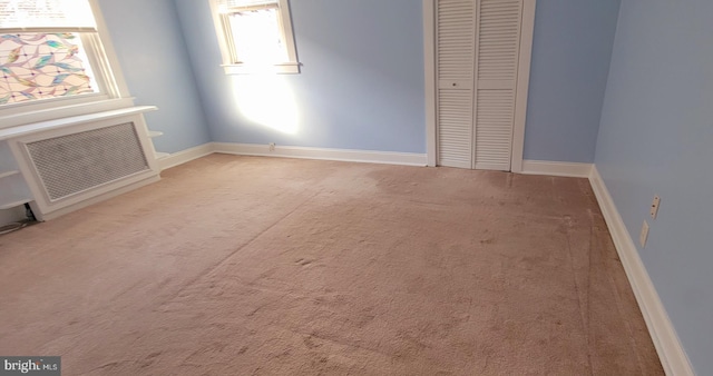 unfurnished bedroom with baseboards, carpet floors, a closet, and visible vents