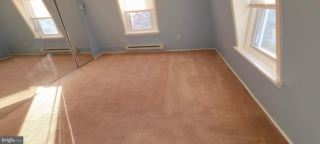 carpeted empty room with a baseboard heating unit, baseboards, and baseboard heating