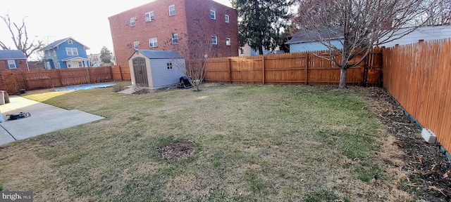 view of yard with a fenced backyard, a patio, an outbuilding, and a storage shed