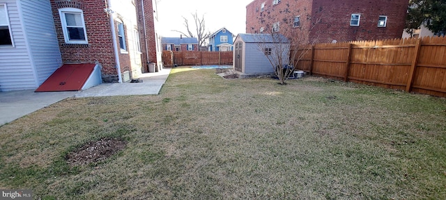 view of yard with a fenced backyard, a shed, and an outdoor structure