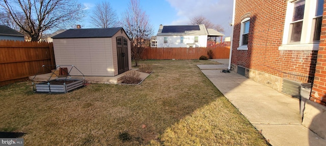 view of yard with a storage unit, an outdoor structure, and a fenced backyard