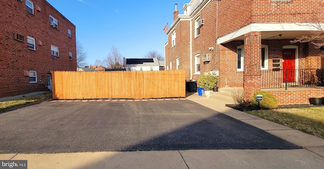 view of property exterior with brick siding and fence