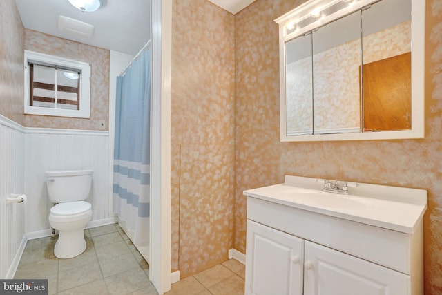 full bathroom with a wainscoted wall, toilet, and wallpapered walls