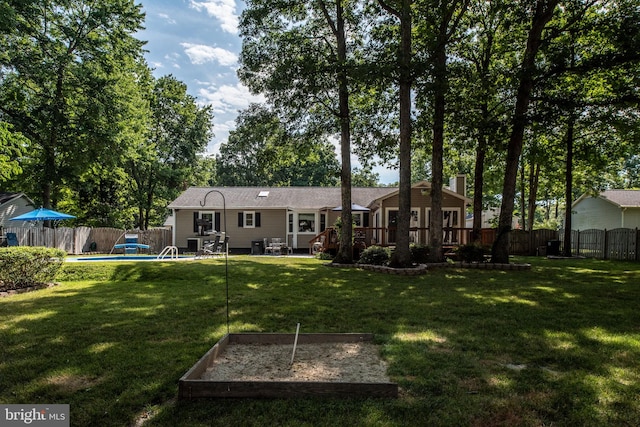 rear view of property with a yard, a deck, a fenced in pool, and a fenced backyard