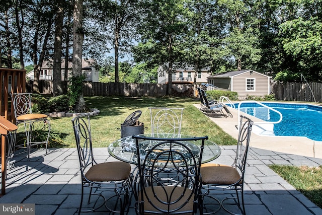 view of swimming pool with outdoor dining space, a patio area, a yard, and a fenced backyard