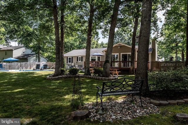 back of house with a fenced in pool, a wooden deck, a yard, and fence