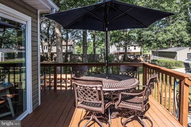 deck featuring outdoor dining area and fence