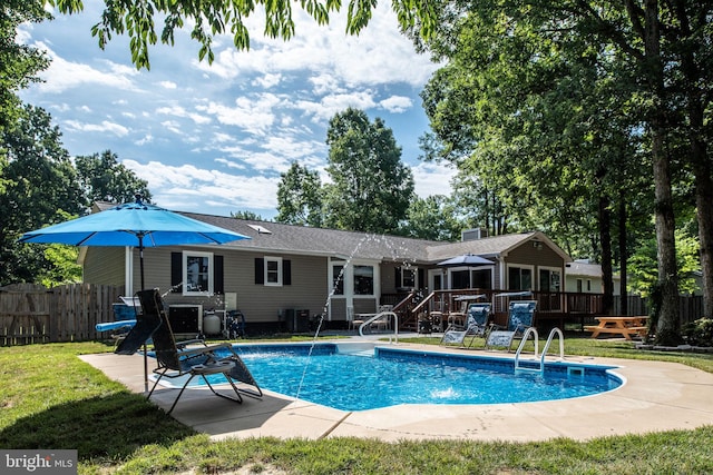 view of swimming pool featuring a fenced in pool, fence, a lawn, a deck, and a patio