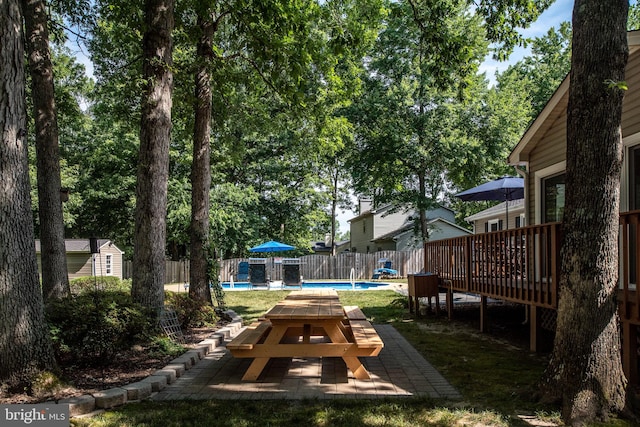 view of yard featuring a fenced in pool, a wooden deck, and fence