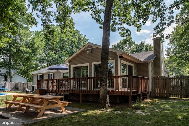 rear view of property featuring a gate, a deck, a chimney, and fence