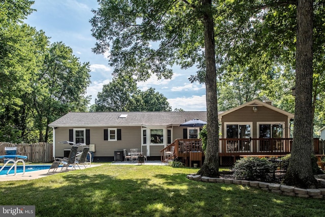 back of house with a fenced in pool, fence, a yard, a deck, and a patio