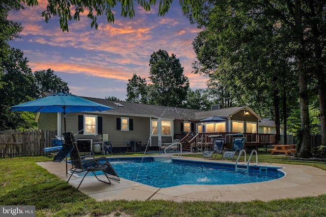 rear view of property featuring a fenced in pool, fence, a yard, a deck, and a patio