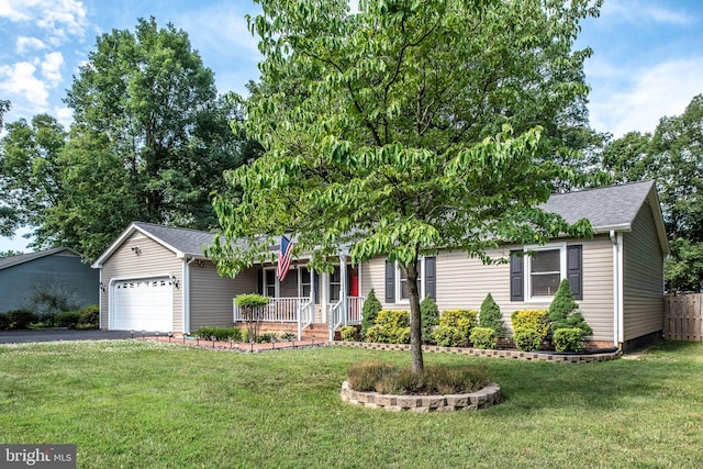 ranch-style house featuring a garage, a front yard, covered porch, and driveway