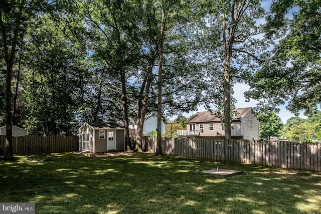 view of yard with an outbuilding, a shed, and a fenced backyard