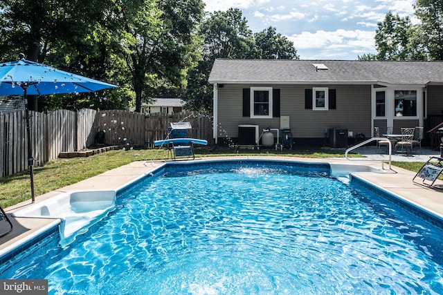 view of pool featuring a fenced in pool, a patio, central air condition unit, and fence