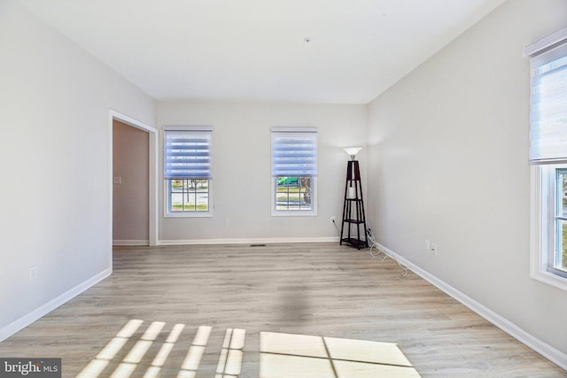 unfurnished room with baseboards and light wood finished floors