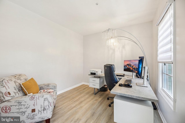 office area with a notable chandelier, baseboards, and light wood-style floors