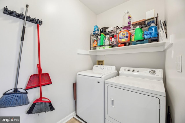 clothes washing area featuring laundry area, washing machine and dryer, and baseboards