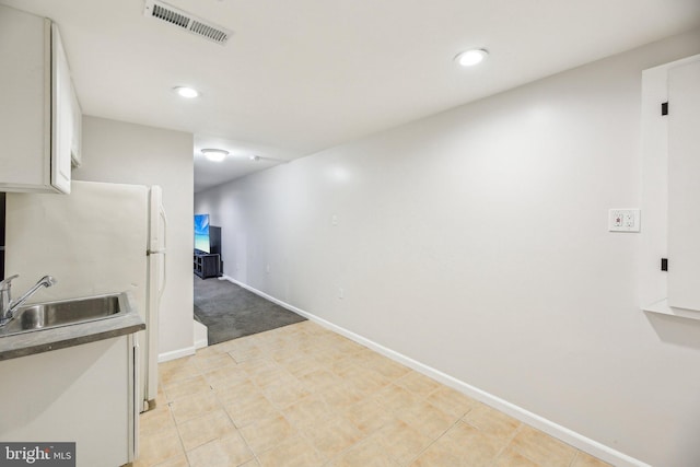 interior space with visible vents, recessed lighting, baseboards, and a sink