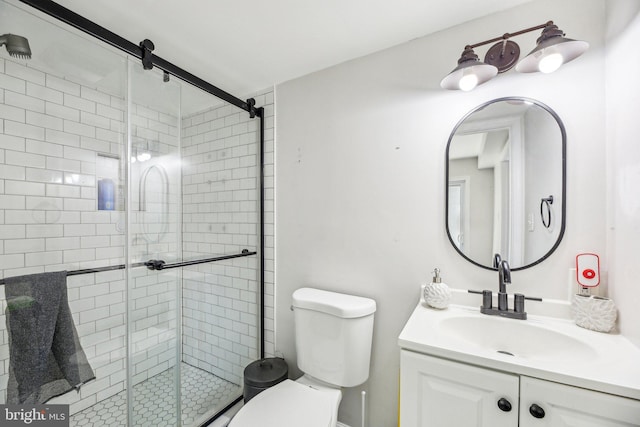 bathroom featuring vanity, a shower stall, and toilet