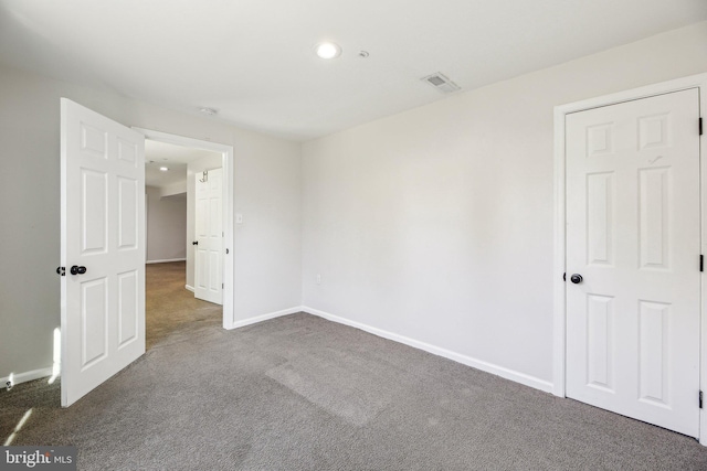 spare room with visible vents, carpet flooring, and baseboards