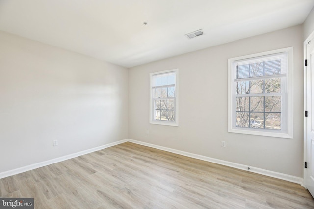 unfurnished room with visible vents, baseboards, and light wood finished floors