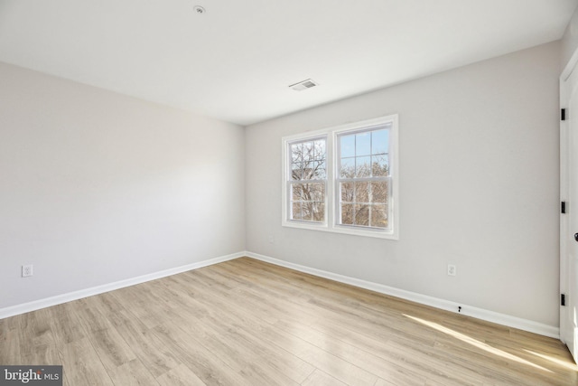 unfurnished room with visible vents, light wood-style floors, and baseboards