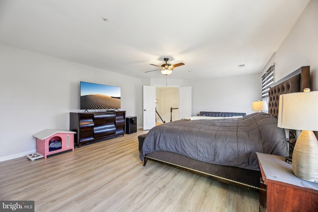 bedroom featuring ceiling fan, visible vents, baseboards, and light wood-style flooring