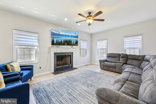 living area featuring a high end fireplace, baseboards, ceiling fan, recessed lighting, and wood finished floors