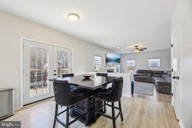 dining space featuring light wood finished floors, french doors, baseboards, and ceiling fan