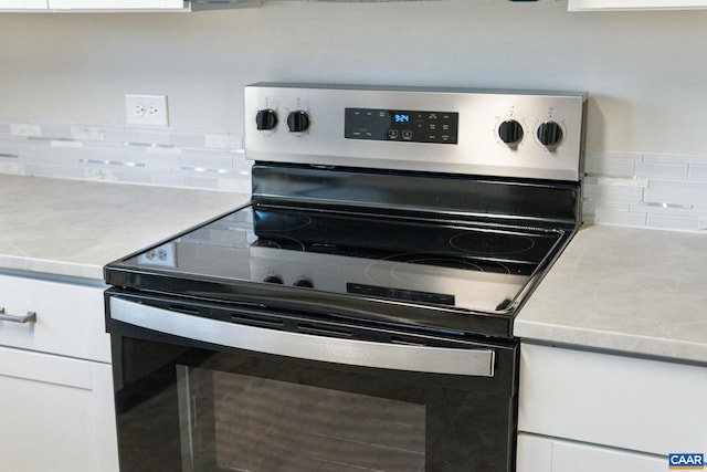 kitchen with stainless steel range with electric stovetop, white cabinetry, and light countertops