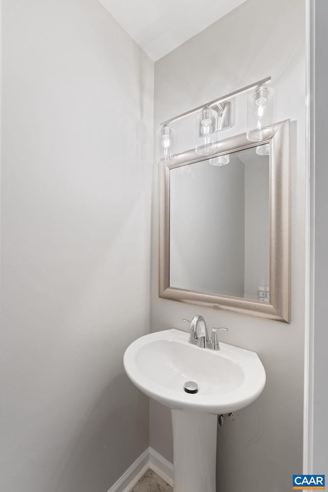 bathroom featuring baseboards and a sink