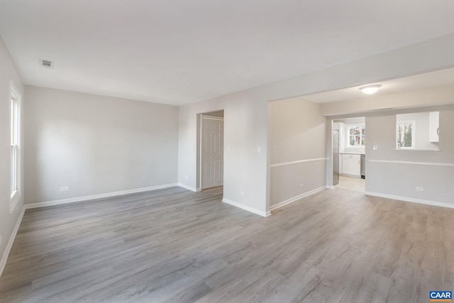 spare room with visible vents, light wood-style floors, and baseboards