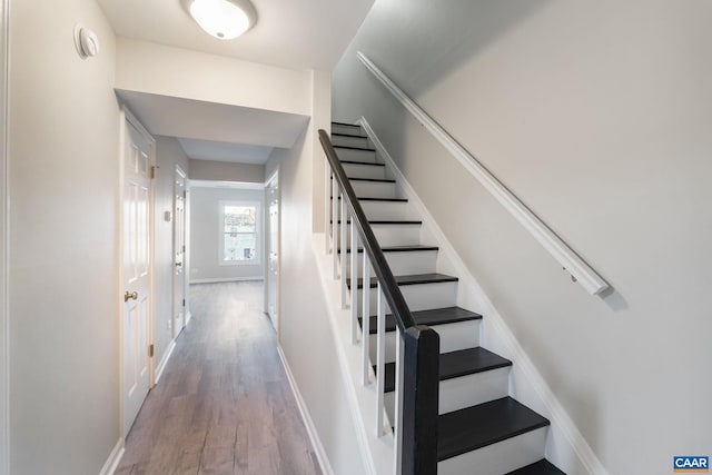 stairway featuring baseboards and wood finished floors