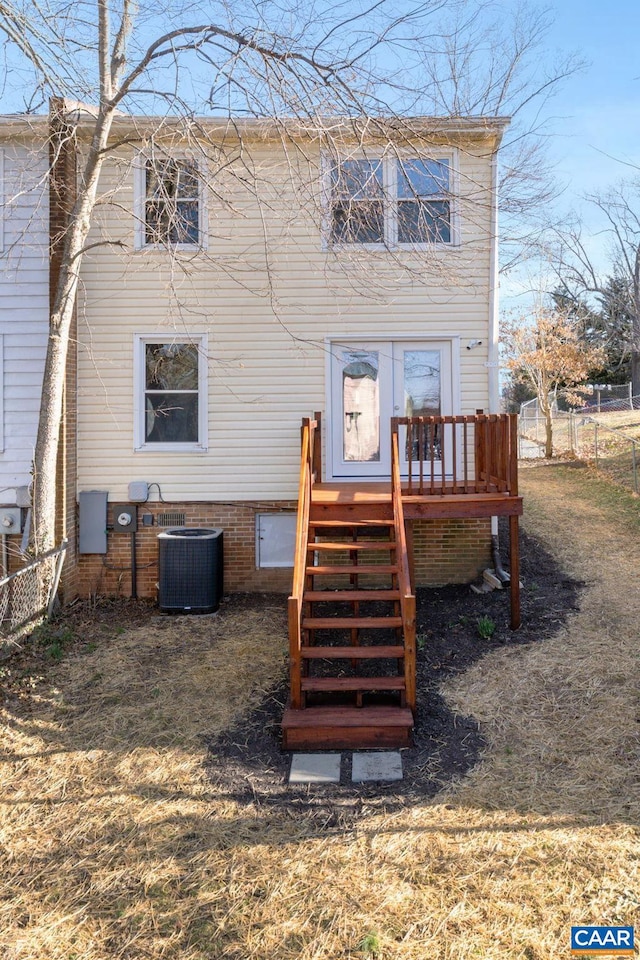 back of house with central air condition unit, a deck, and fence