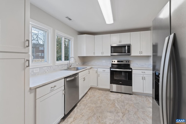 kitchen featuring a sink, visible vents, appliances with stainless steel finishes, and white cabinets