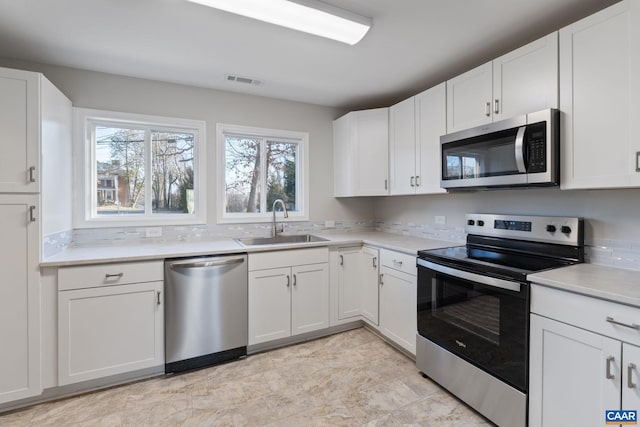 kitchen with visible vents, appliances with stainless steel finishes, light countertops, and a sink