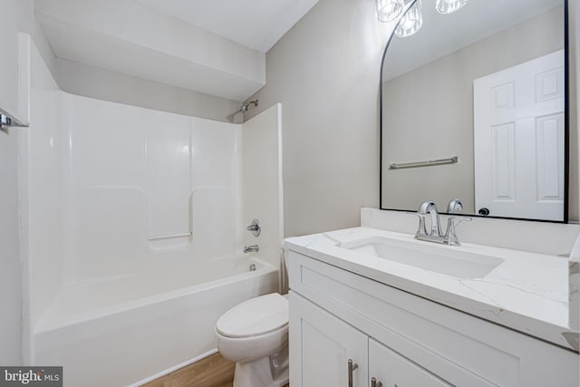 full bath featuring vanity, wood finished floors, toilet, and washtub / shower combination