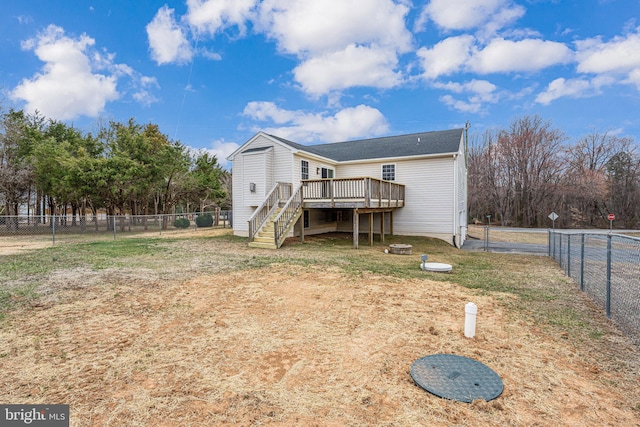 rear view of property with a wooden deck, a fenced backyard, and stairs