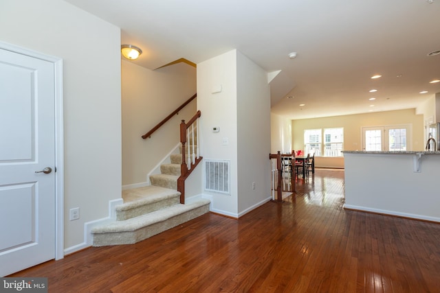 stairway featuring visible vents, recessed lighting, baseboards, and wood-type flooring