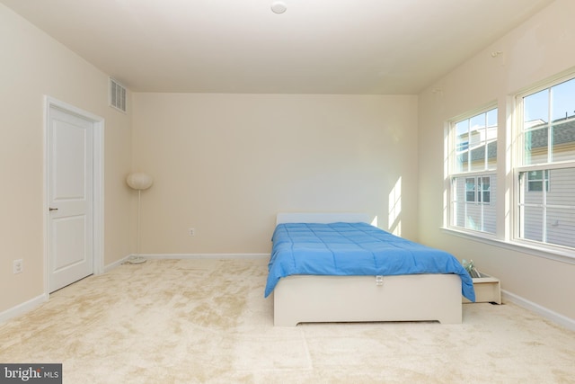 carpeted bedroom featuring baseboards and visible vents