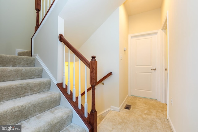 staircase with carpet flooring, baseboards, and visible vents